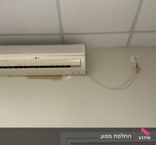 מזגן מותקן על קיר עם חוט חשמל מחובר